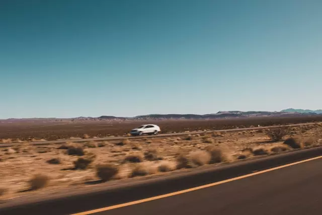 Car on a long trek in the desert